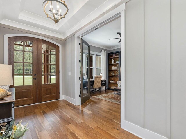 67 Spring Hollow Ct, Pittsboro, NC 27312 - entrance foyer featuring french doors, wood finished floors, a chandelier, ornamental molding, and arched walkways