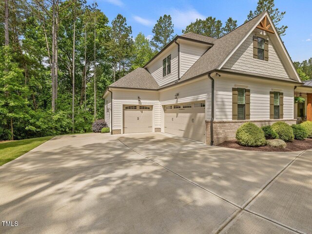 67 Spring Hollow Ct, Pittsboro, NC 27312 - view of home's exterior with a garage, a shingled roof, concrete driveway, and brick siding