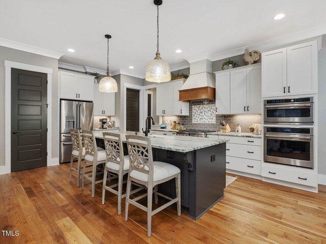 67 Spring Hollow Ct, Pittsboro, NC 27312 - kitchen featuring appliances with stainless steel finishes, custom exhaust hood, ornamental molding, a kitchen bar, and decorative backsplash