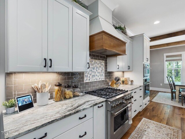 67 Spring Hollow Ct, Pittsboro, NC 27312 - kitchen featuring high end stainless steel range, dark wood finished floors, premium range hood, backsplash, and light stone counters