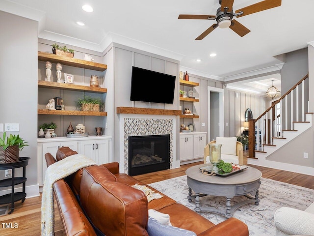 67 Spring Hollow Ct, Pittsboro, NC 27312 - living area featuring ornamental molding, a ceiling fan, stairs, light wood-type flooring, and a fireplace