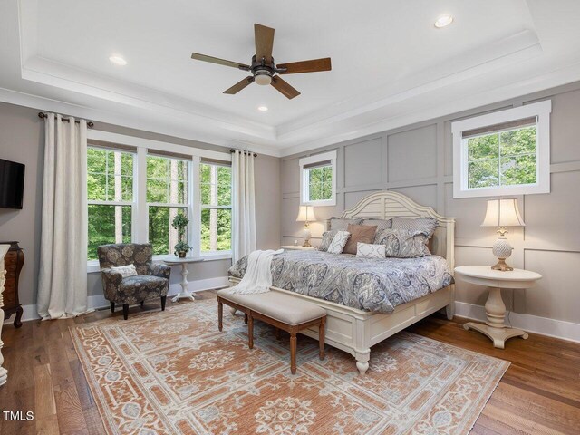 67 Spring Hollow Ct, Pittsboro, NC 27312 - bedroom featuring a raised ceiling, crown molding, wood finished floors, a decorative wall, and baseboards