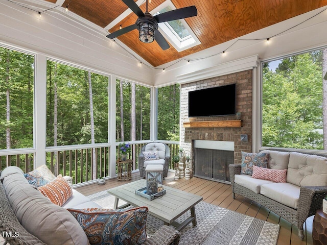 67 Spring Hollow Ct, Pittsboro, NC 27312 - sunroom with an outdoor living space with a fireplace, a ceiling fan, a skylight, plenty of natural light, and vaulted ceiling