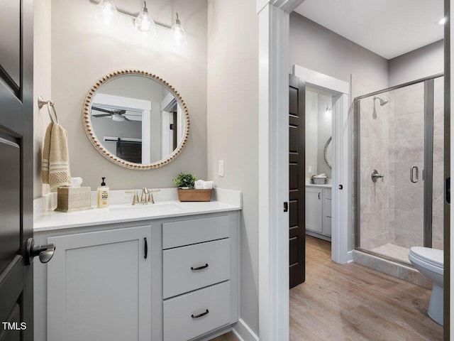 67 Spring Hollow Ct, Pittsboro, NC 27312 - bathroom featuring vanity, ceiling fan, a shower stall, wood finished floors, and toilet