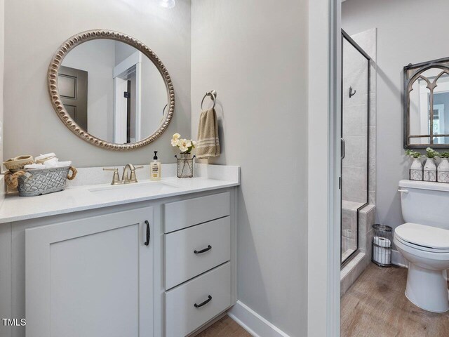 67 Spring Hollow Ct, Pittsboro, NC 27312 - full bathroom featuring toilet, a stall shower, vanity, and wood finished floors