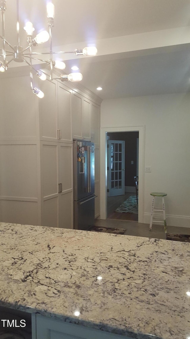 2236 The Cir, Raleigh, NC 27608 - kitchen featuring high end fridge, light stone countertops, a chandelier, baseboards, and hanging light fixtures