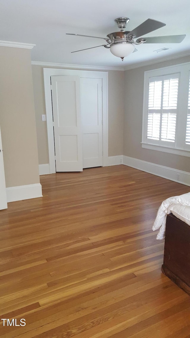 2236 The Cir, Raleigh, NC 27608 - unfurnished bedroom with crown molding, light wood-style flooring, baseboards, a closet, and ceiling fan