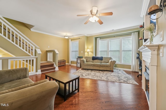 9808 Rainsong Dr, Wake Forest, NC 27587 - living area featuring stairs, a lit fireplace, a ceiling fan, ornamental molding, and wood finished floors