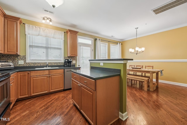 9808 Rainsong Dr, Wake Forest, NC 27587 - kitchen with appliances with stainless steel finishes, a chandelier, a sink, dark countertops, and dark wood finished floors