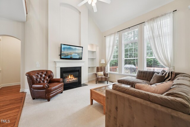7 Teahouse Ct, Durham, NC 27707 - living area featuring arched walkways, a fireplace with flush hearth, baseboards, high vaulted ceiling, and built in shelves