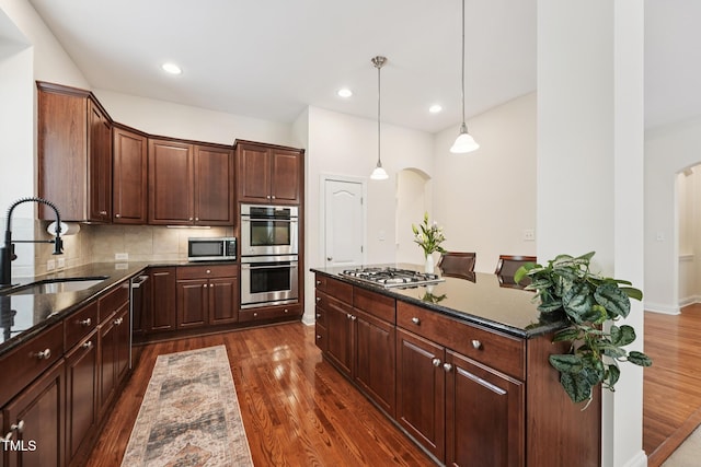 7 Teahouse Ct, Durham, NC 27707 - kitchen featuring appliances with stainless steel finishes, arched walkways, a sink, dark wood-type flooring, and recessed lighting