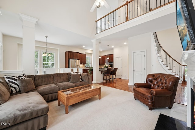 7 Teahouse Ct, Durham, NC 27707 - living room with ceiling fan, a towering ceiling, decorative columns, light wood-type flooring, and stairway