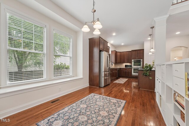 7 Teahouse Ct, Durham, NC 27707 - kitchen with stainless steel appliances, dark brown cabinets, dark wood-style flooring, decorative light fixtures, and baseboards