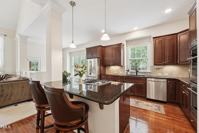 7 Teahouse Ct, Durham, NC 27707 - kitchen featuring appliances with stainless steel finishes, ornate columns, a sink, dark wood-style floors, and open floor plan