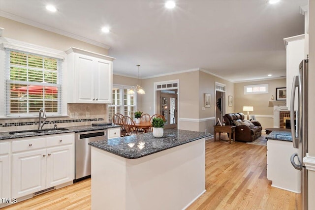 103 Rose Sky Ct, Cary, NC 27513 - kitchen with stainless steel appliances, a sink, white cabinets, dark stone counters, and light wood-type flooring