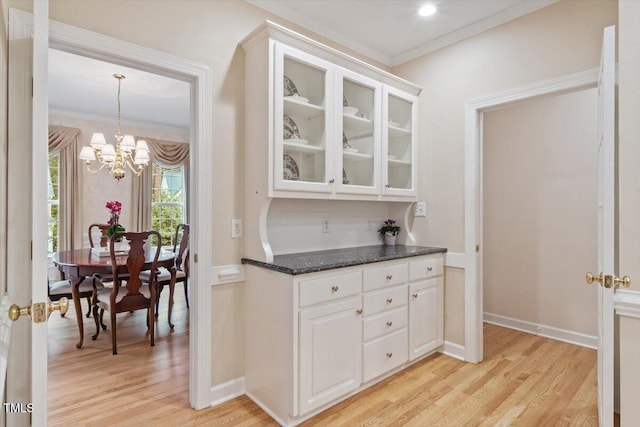 103 Rose Sky Ct, Cary, NC 27513 - kitchen featuring light wood-style floors, crown molding, white cabinets, glass insert cabinets, and a chandelier