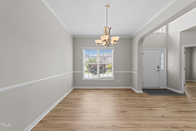 5942 Big Nance Dr, Raleigh, NC 27616 - foyer entrance with arched walkways, a chandelier, light wood-type flooring, crown molding, and baseboards