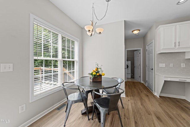 5942 Big Nance Dr, Raleigh, NC 27616 - dining space featuring washer / dryer, baseboards, light wood-style flooring, and a chandelier