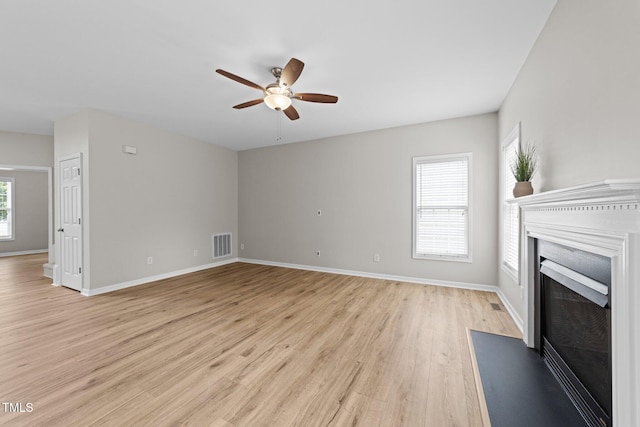 5942 Big Nance Dr, Raleigh, NC 27616 - unfurnished living room with ceiling fan, light wood-style floors, a fireplace with flush hearth, and baseboards