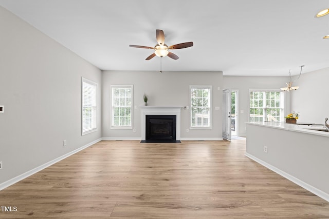 5942 Big Nance Dr, Raleigh, NC 27616 - unfurnished living room with light wood-type flooring, ceiling fan, a fireplace with flush hearth, baseboards, and recessed lighting