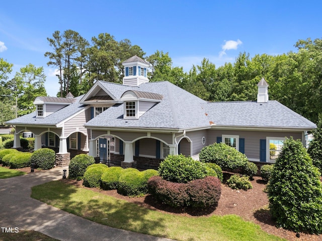 5942 Big Nance Dr, Raleigh, NC 27616 - view of front of house featuring stone siding, a porch, a shingled roof, and a chimney