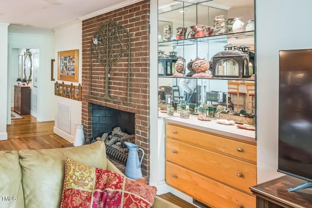 582 Wimbleton Dr, Raleigh, NC 27609 - living area with crown molding, wood finished floors, a fireplace, and baseboards