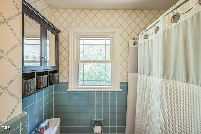 582 Wimbleton Dr, Raleigh, NC 27609 - bathroom with tile walls, healthy amount of natural light, a shower with shower curtain, and a wainscoted wall