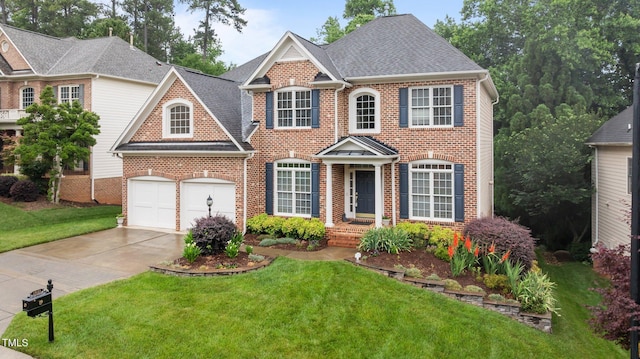 13121 Sargas St, Raleigh, NC 27614 - colonial house featuring brick siding, concrete driveway, a front yard, and a garage