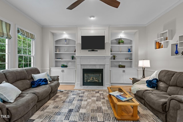 13121 Sargas St, Raleigh, NC 27614 - living area with built in shelves, ornamental molding, a ceiling fan, a premium fireplace, and light wood finished floors