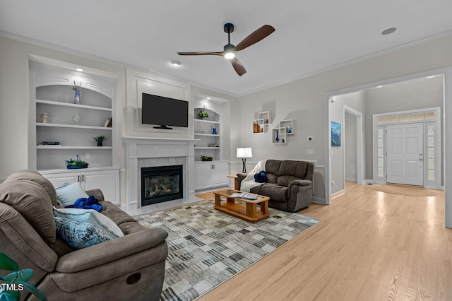 13121 Sargas St, Raleigh, NC 27614 - living area featuring ceiling fan, light wood finished floors, ornamental molding, a high end fireplace, and built in shelves