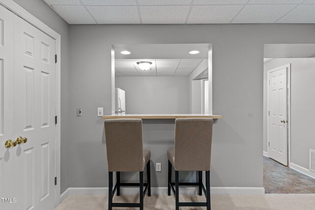 13121 Sargas St, Raleigh, NC 27614 - kitchen with a drop ceiling, baseboards, freestanding refrigerator, and a breakfast bar