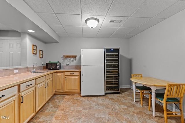 13121 Sargas St, Raleigh, NC 27614 - kitchen with freestanding refrigerator, a sink, black microwave, light brown cabinets, and light countertops