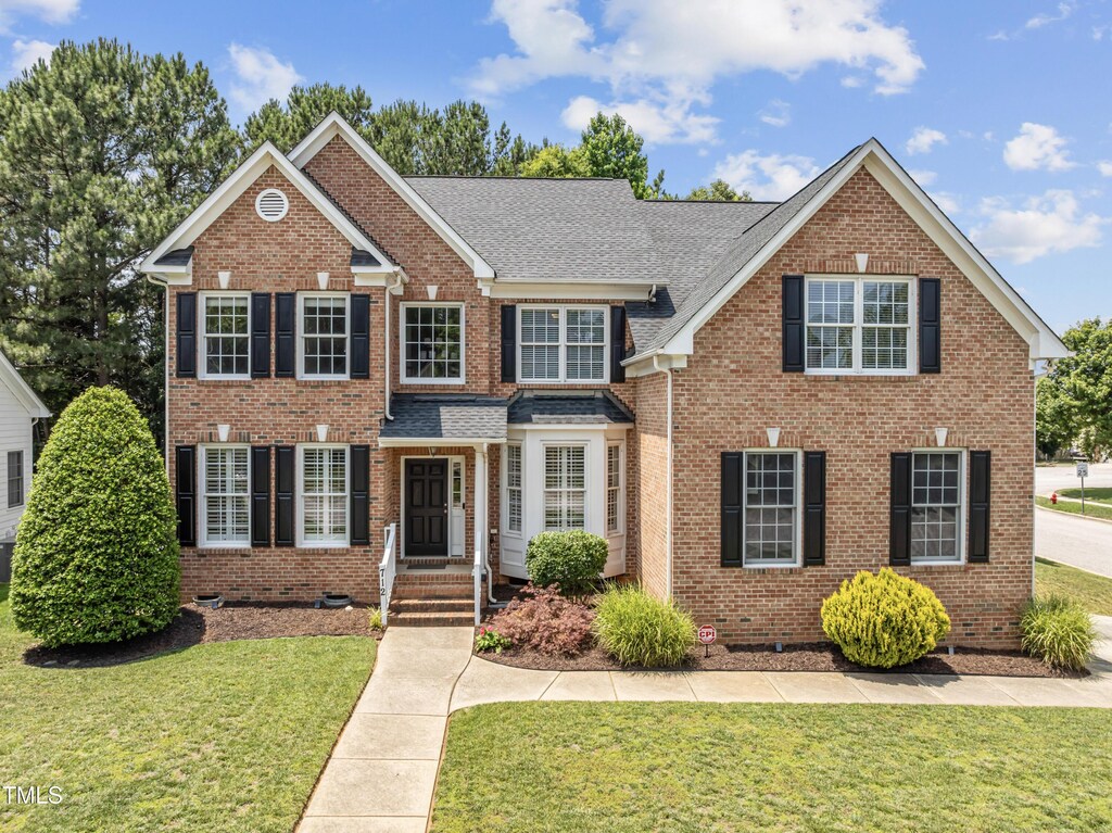 712 Brittley Way, Apex, NC 27502 - view of front of house with crawl space, brick siding, a front yard, and a shingled roof
