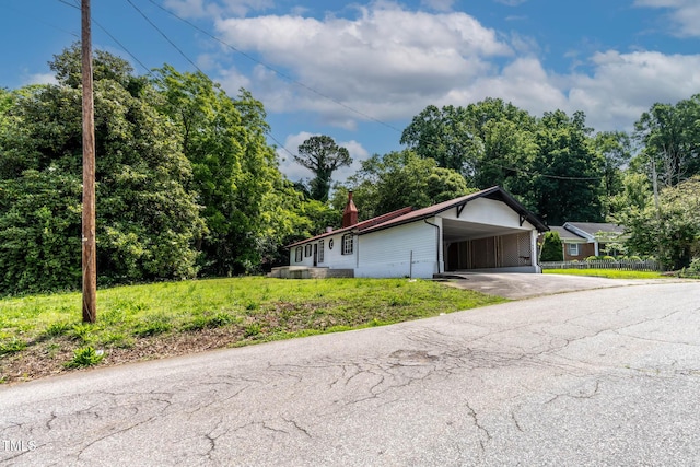 519 W Raleigh St, Siler City, NC 27344 - view of front facade with concrete driveway, an attached carport, and view of wooded area