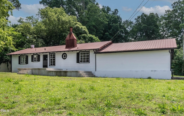 519 W Raleigh St, Siler City, NC 27344 - view of front of home featuring a front yard, metal roof, and a chimney