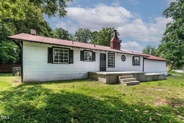 519 W Raleigh St, Siler City, NC 27344 - rear view of property with a chimney, a lawn, and metal roof