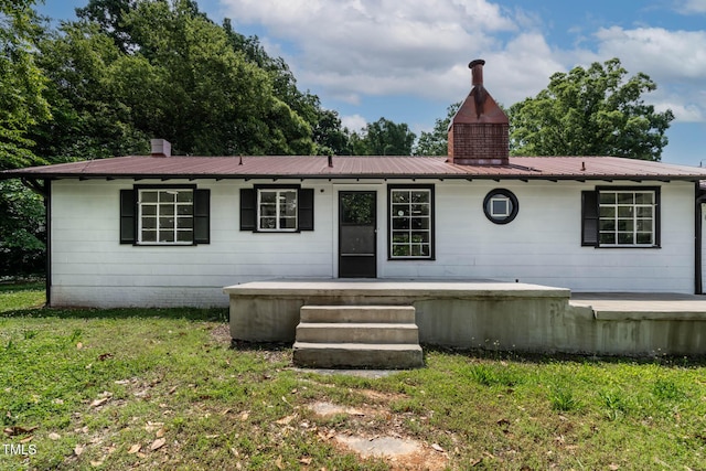 519 W Raleigh St, Siler City, NC 27344 - ranch-style home with a front lawn, a chimney, and metal roof