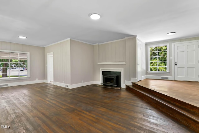 519 W Raleigh St, Siler City, NC 27344 - unfurnished living room featuring crown molding, healthy amount of natural light, wood finished floors, baseboards, and a fireplace with flush hearth