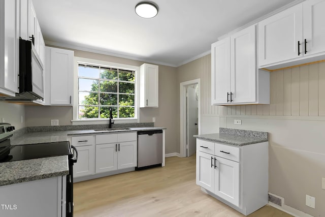 519 W Raleigh St, Siler City, NC 27344 - kitchen with stainless steel appliances, a sink, light wood-style floors, white cabinetry, and stone countertops
