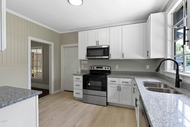 519 W Raleigh St, Siler City, NC 27344 - kitchen featuring stainless steel appliances, a sink, crown molding, white cabinets, and light wood-type flooring