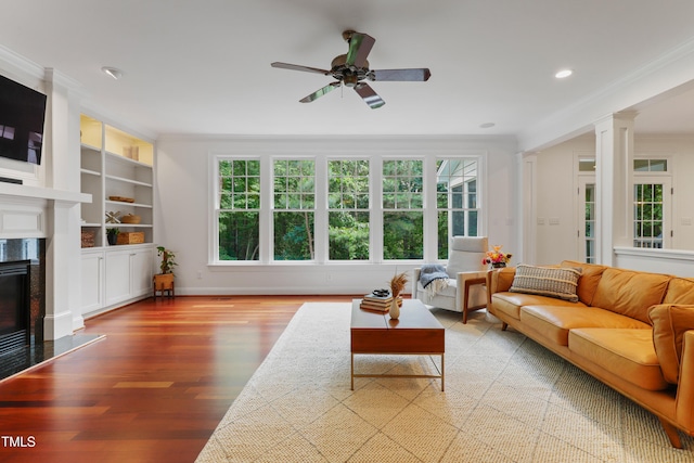 118 Killingsworth Dr, Cary, NC 27518 - living room featuring ornamental molding, plenty of natural light, a fireplace, wood finished floors, and built in shelves