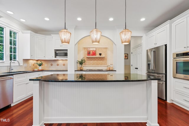 118 Killingsworth Dr, Cary, NC 27518 - kitchen with stainless steel appliances, ornamental molding, a sink, a center island, and white cabinets