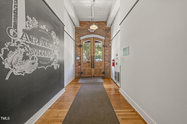 1535 Caraleigh Mills Ct Unit 210, Raleigh, NC 27603 - entrance foyer featuring wood finished floors, baseboards, brick wall, and wooden ceiling