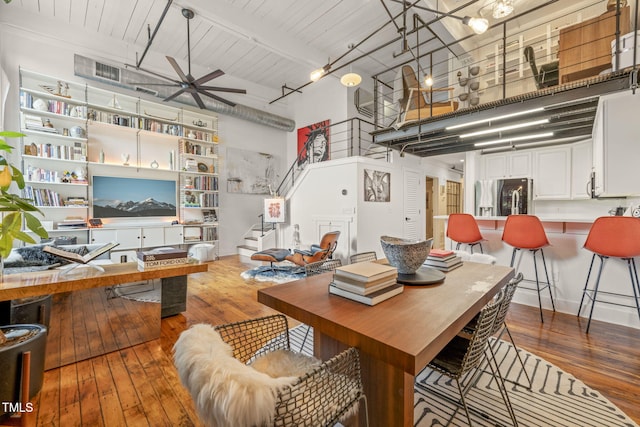 1535 Caraleigh Mills Ct Unit 210, Raleigh, NC 27603 - dining room featuring a towering ceiling, wood-type flooring, stairs, a ceiling fan, and beam ceiling