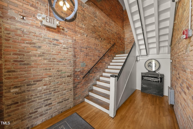 1535 Caraleigh Mills Ct Unit 210, Raleigh, NC 27603 - stairway featuring a high ceiling, wood-type flooring, and brick wall