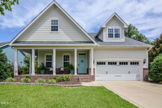 18 Heathgreen Dr, Clayton, NC 27527 - view of front facade with a porch, brick siding, driveway, a shingled roof, and an attached garage