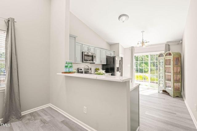 1375 Quail Cir, Creedmoor, NC 27522 - kitchen with appliances with stainless steel finishes, light countertops, backsplash, a chandelier, and light wood finished floors