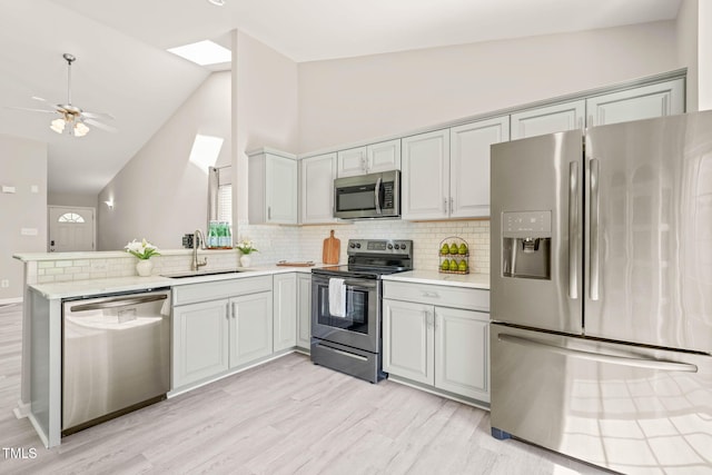 1375 Quail Cir, Creedmoor, NC 27522 - kitchen with appliances with stainless steel finishes, a sink, a peninsula, light wood-style floors, and backsplash
