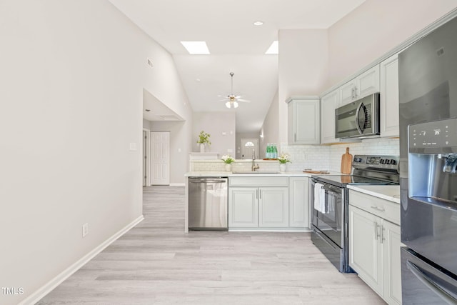 1375 Quail Cir, Creedmoor, NC 27522 - kitchen featuring appliances with stainless steel finishes, a sink, a peninsula, decorative backsplash, and light wood-style floors