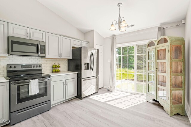1375 Quail Cir, Creedmoor, NC 27522 - kitchen with appliances with stainless steel finishes, backsplash, vaulted ceiling, light countertops, and a chandelier